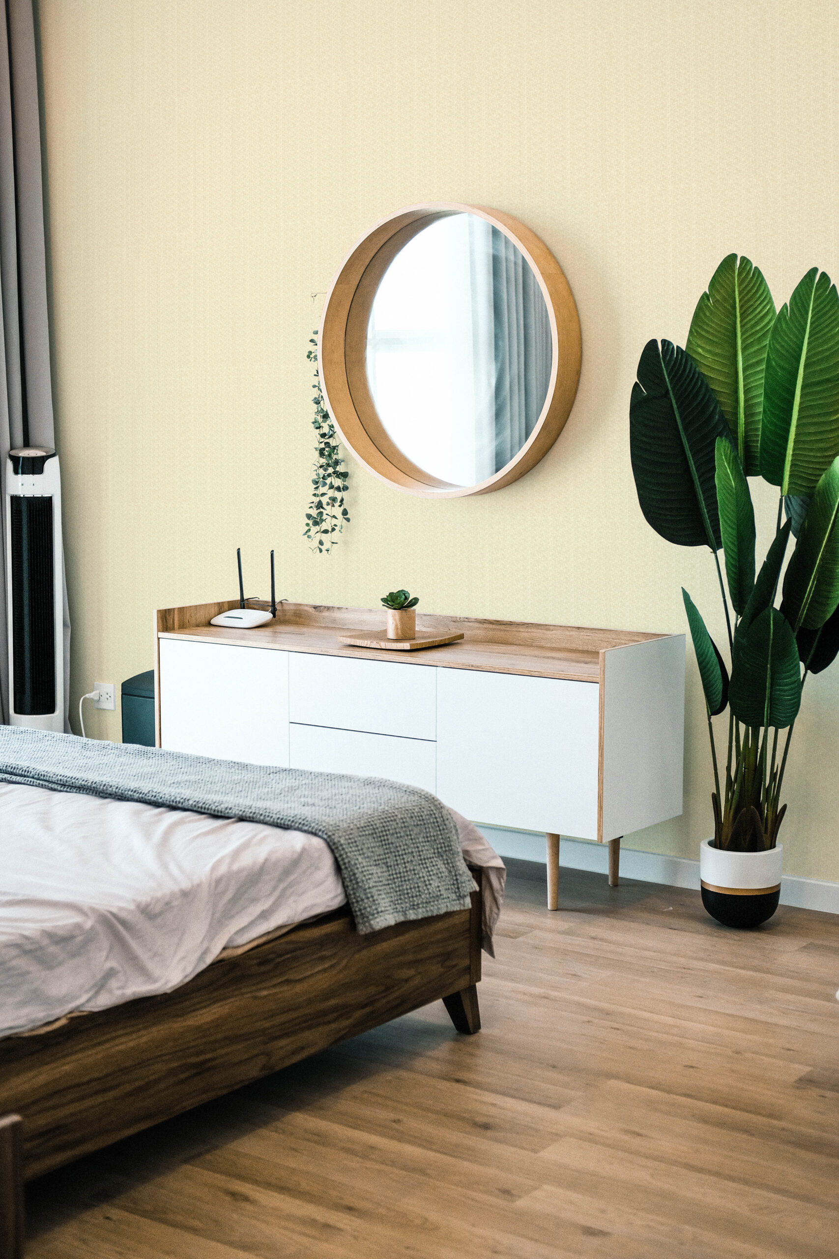 Fine Beige Fabric Look self-adhesive wallpaper on a bedroom wall behind a round mirror and a low white dresser.
