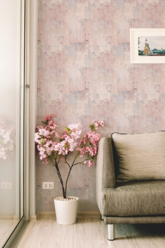 Soft Blush Wash Effect peel and stick wallpaper with a soft pink and gray wash effect shown as a full wall behind a sofa.