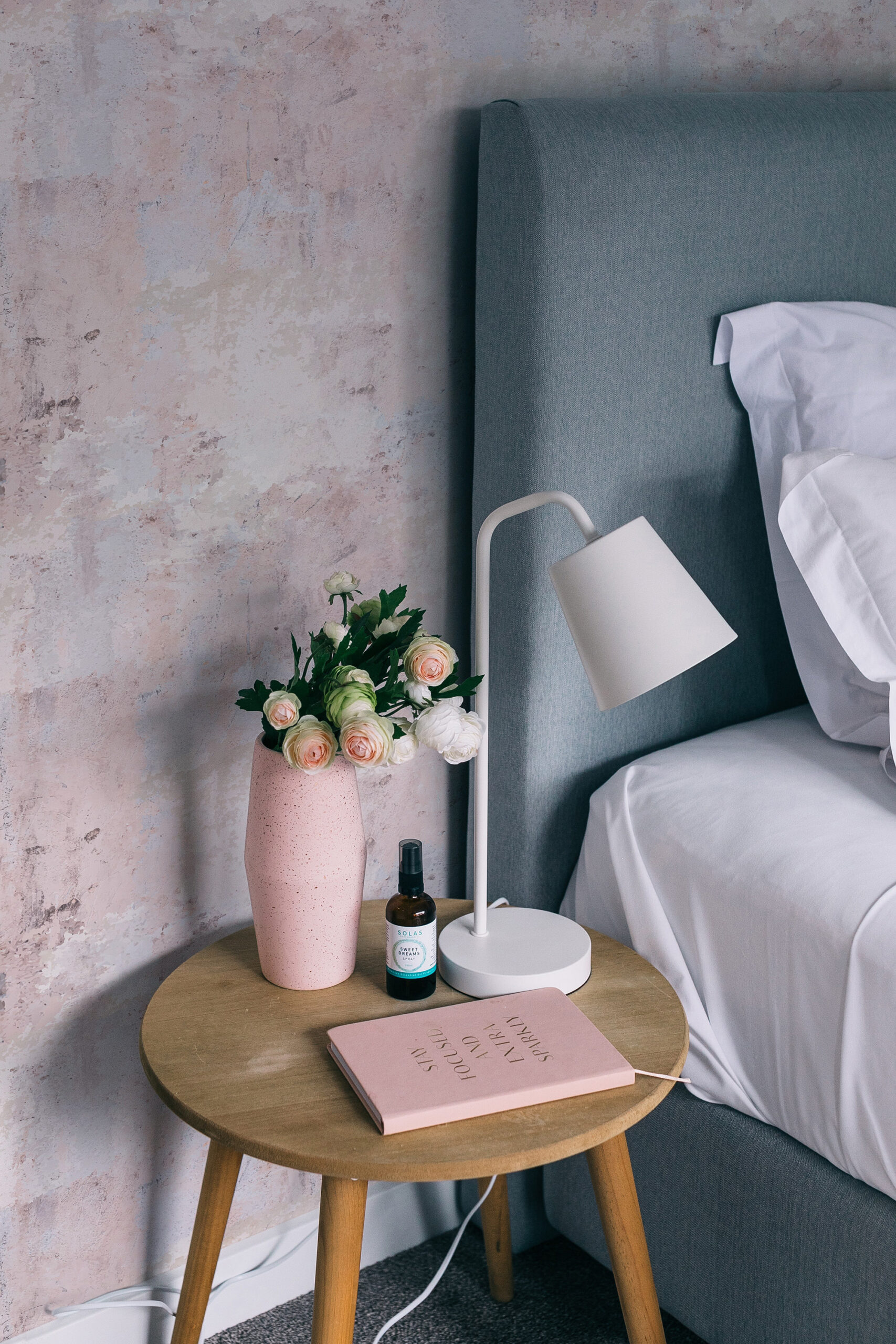 Soft Blush Wash pre-pasted wallpaper creates a mottled blush plaster look behind the bed and bedside table.