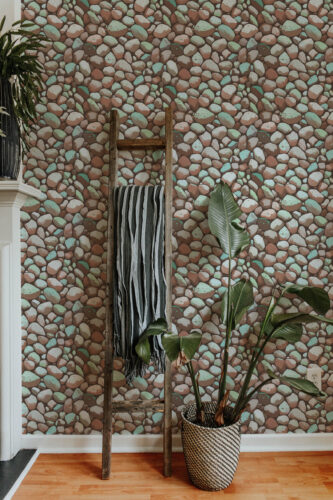 Dense Brown Stone Look peel and stick wallpaper with a multicolor pebble pattern covering the wall behind a wooden ladder.