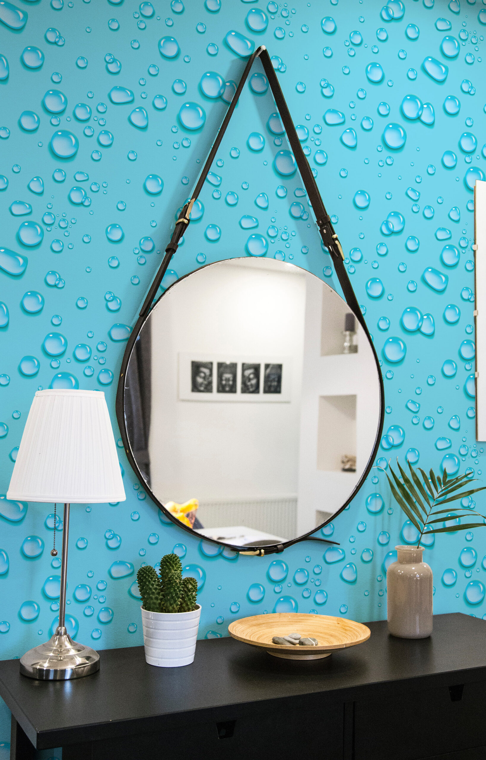 Dense Turquoise Raindrops non-pasted wallpaper with glossy water droplet pattern behind a round hanging mirror.