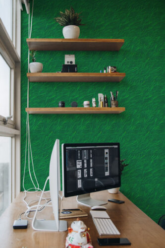Grass Look peel and stick wallpaper covers the office wall behind floating shelves with a lively green lawn texture.