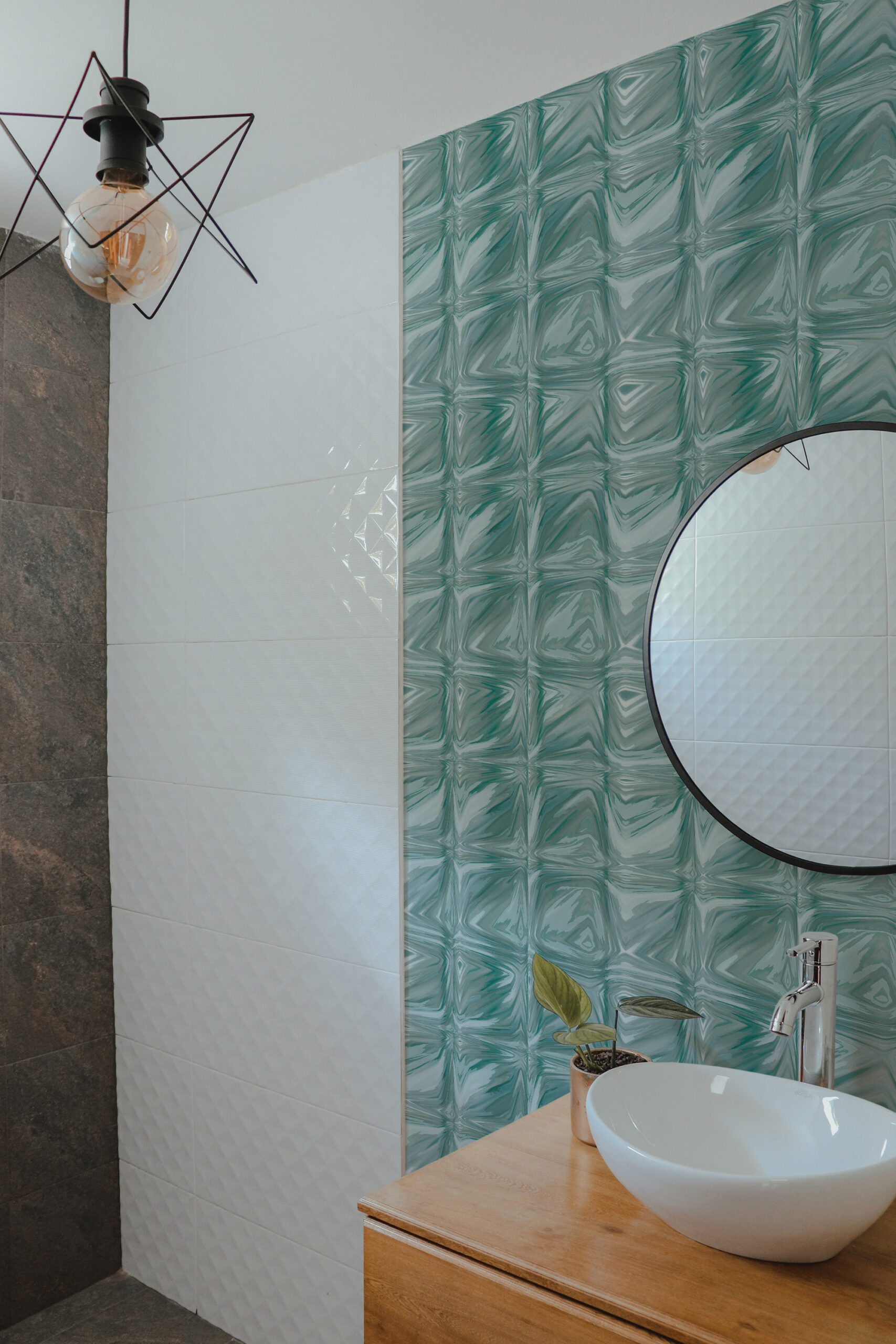 Teal Tile Look non-pasted wallpaper in a bathroom, with glossy teal square tiles behind a round mirror.