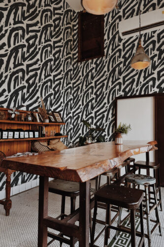 Bold Black Brush Strokes peel and stick wallpaper covering a dining nook wall with sweeping black brush marks on white.