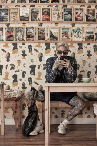 Boho Celestial Statue pre-pasted wallpaper with black and ochre statues, moons, and stars across the wall.