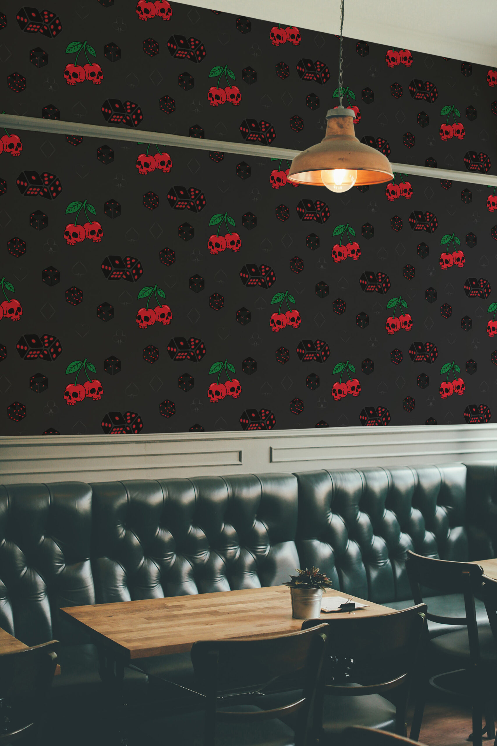 Skull Cherry Jackpot peel and stick wallpaper with red skull cherries and dice pattern on a dark wall above a booth seat.