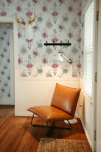 Modern Floral Geometry peel and stick wallpaper with colorful floral sketches and fine black geometric linework on a full wall.