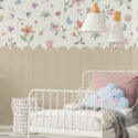 Whimsical Floral Border floral scatter removable wall mural with a tan scalloped border above a child’s white metal bed.
