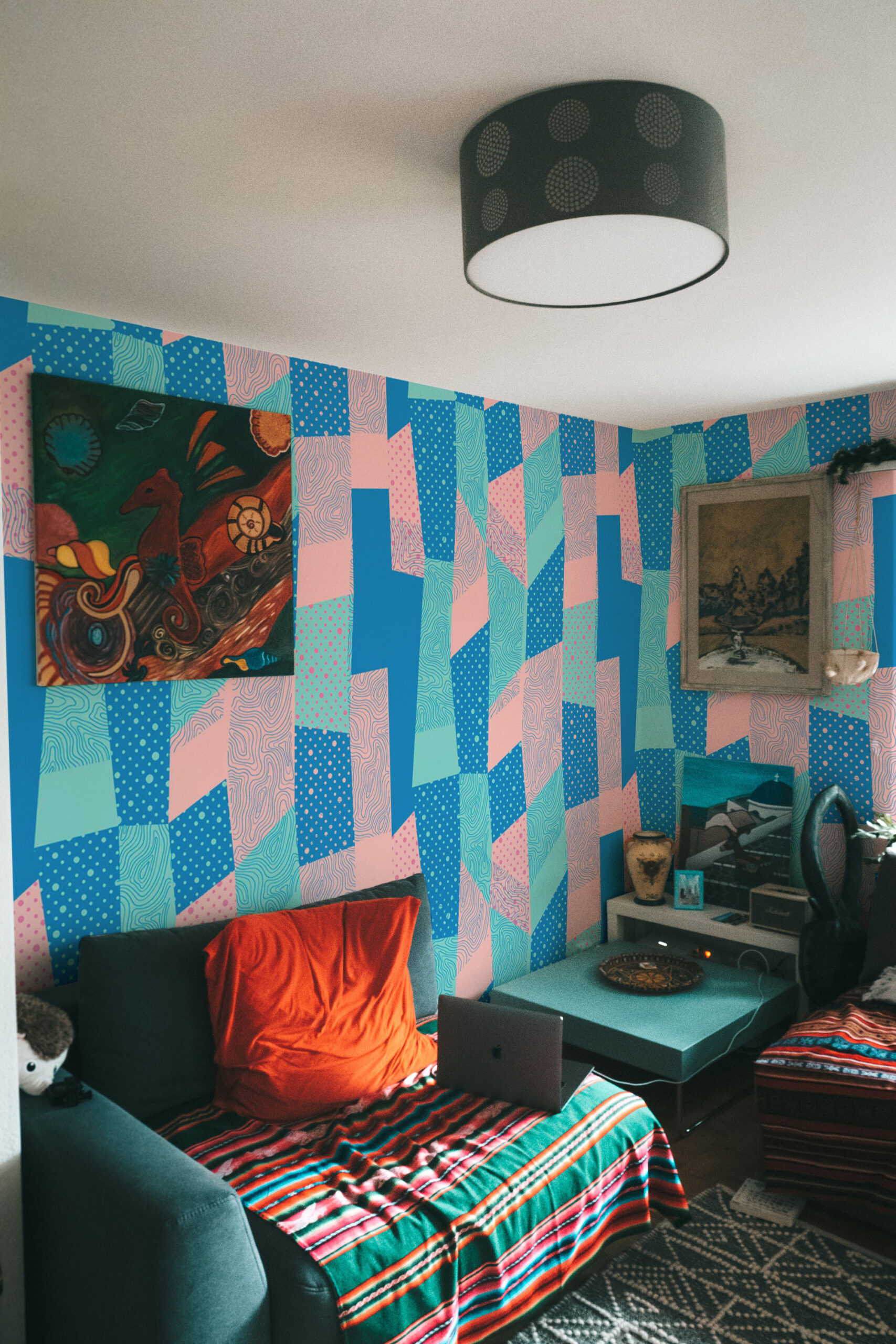 Retro Geometric Patchwork covers the bedroom corner as a wallpaper mural with bold teal, pink, and blue abstract blocks.