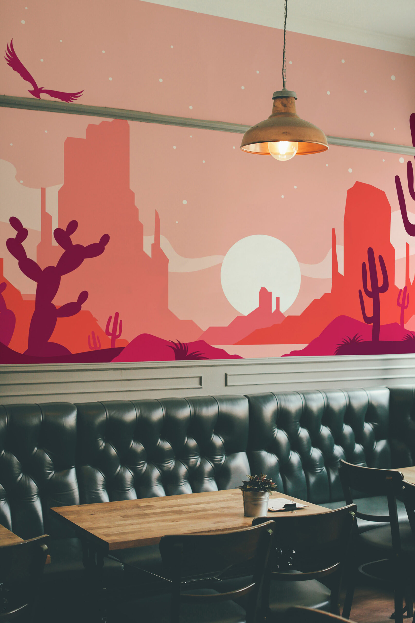 Pink Desert Sunset wall mural showing a stylized cactus desert landscape with a pale sun across a restaurant wall.