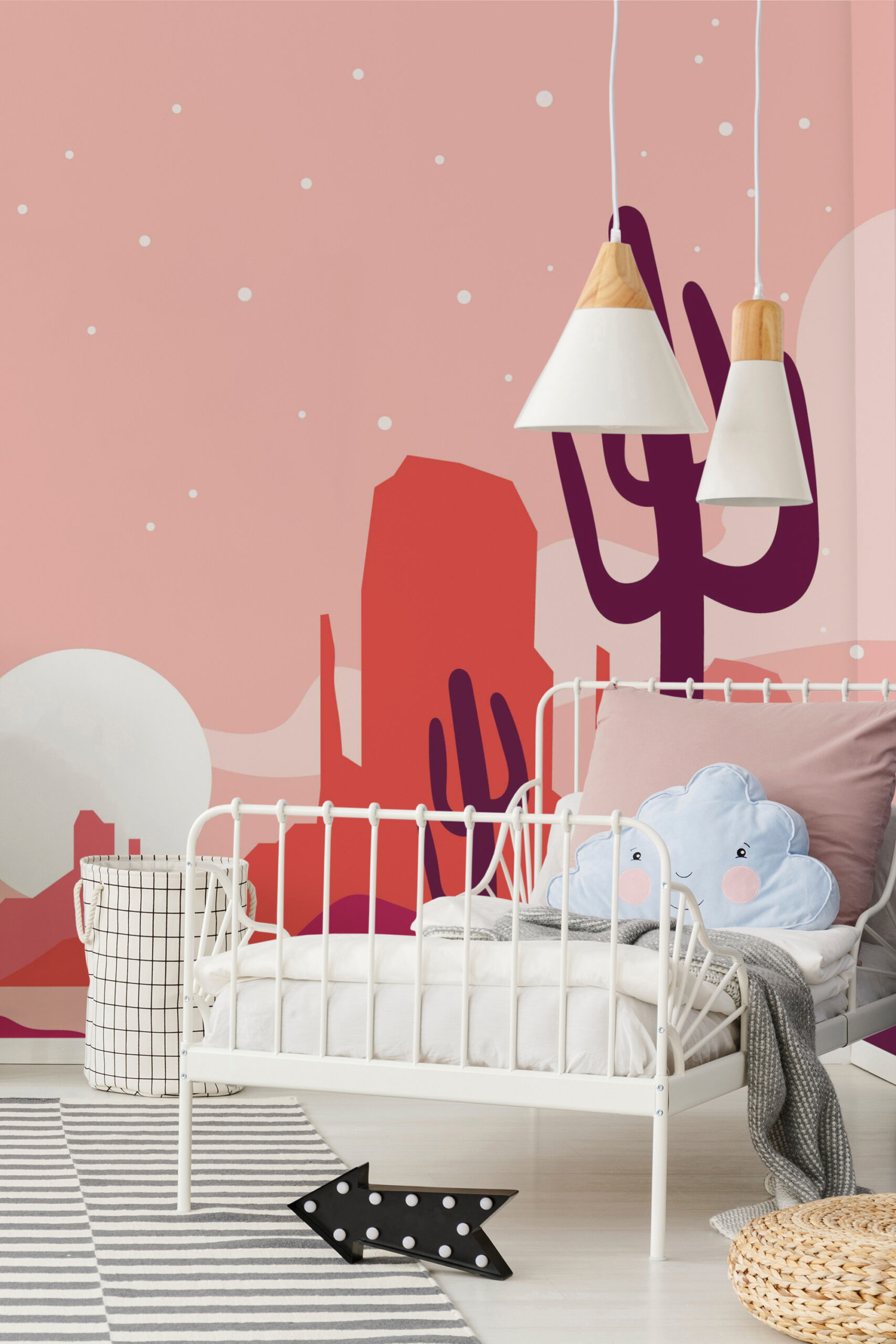Pink Desert Sunset wall mural behind a white metal bed, with cactus silhouettes and red desert shapes on a pink sky.