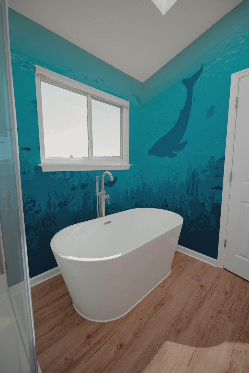 Tranquil Sea Silhouettes wraps two bathroom walls as a wallpaper mural, showing a whale silhouette and seaweed in deep blue water.