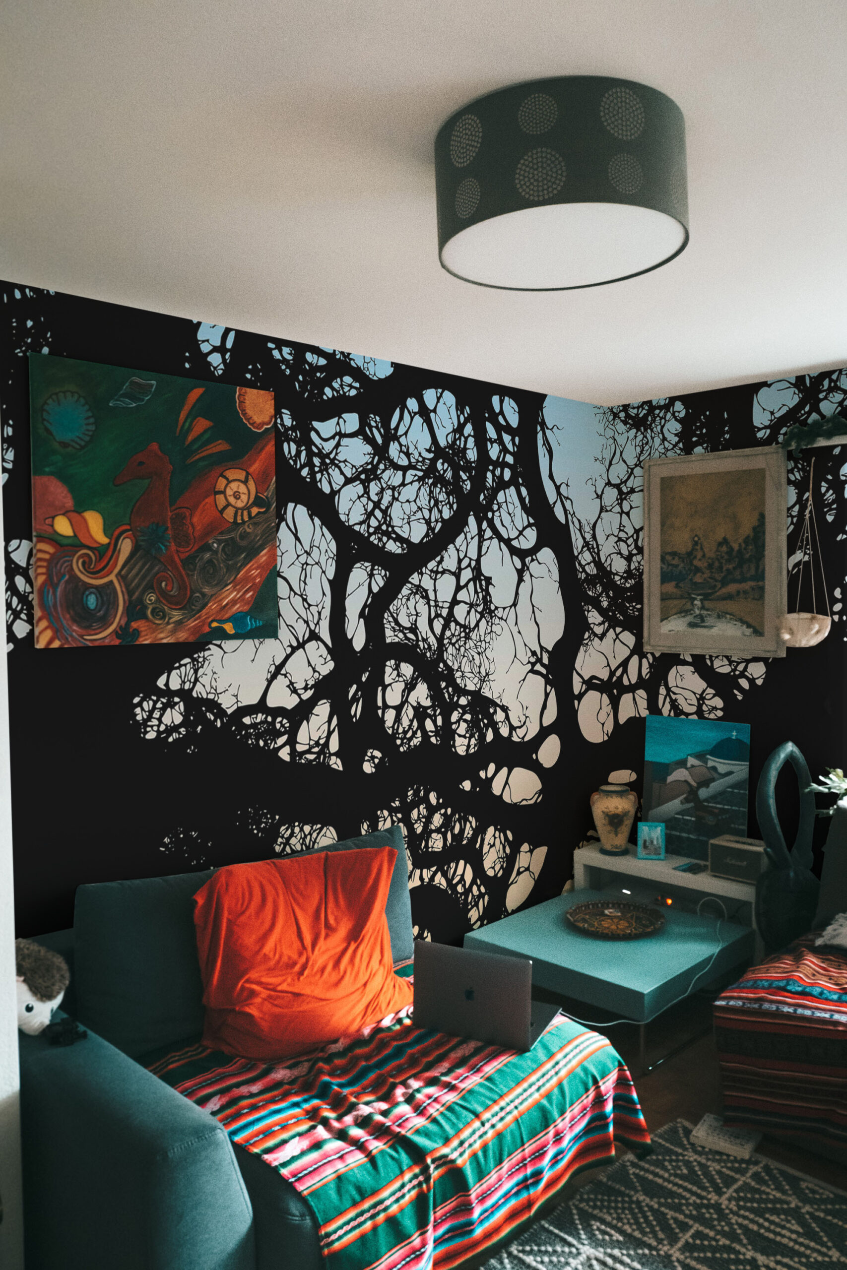Moody Branch Canopy wall mural spanning a corner bedroom wall with black tree-branch silhouettes against a pale sky.