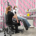 Bold Pink Shark Stripes removable wallpaper with wavy hot-pink vertical stripes and black-and-white sharks in swirling clouds.