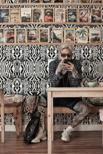 Vintage Black Tattoo Machine peel and stick wallpaper with mirrored tattoo machines, floral scrollwork, and black-and-white wavy stripes.