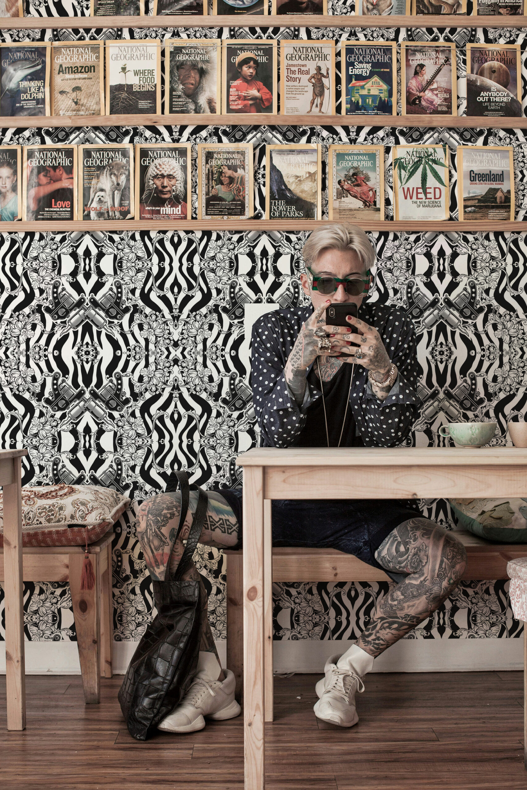 Vintage Black Tattoo Machine peel and stick wallpaper with mirrored tattoo machines, floral scrollwork, and black-and-white wavy stripes.