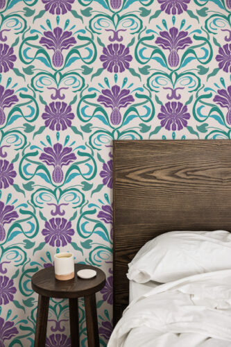 Art Nouveau Purple Floral peel and stick wallpaper with purple flowers and teal scrollwork on a bedroom wall behind the bed.