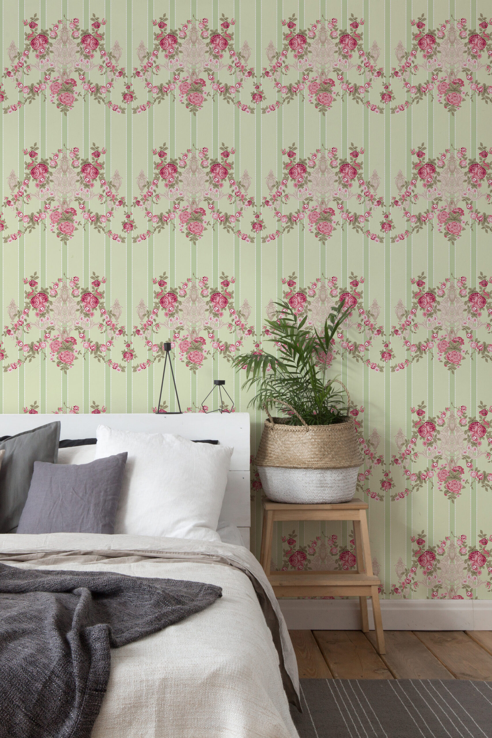 Vintage Floral Stripe self-adhesive wallpaper with pink rose garlands and vertical stripes behind a bed in a bedroom.