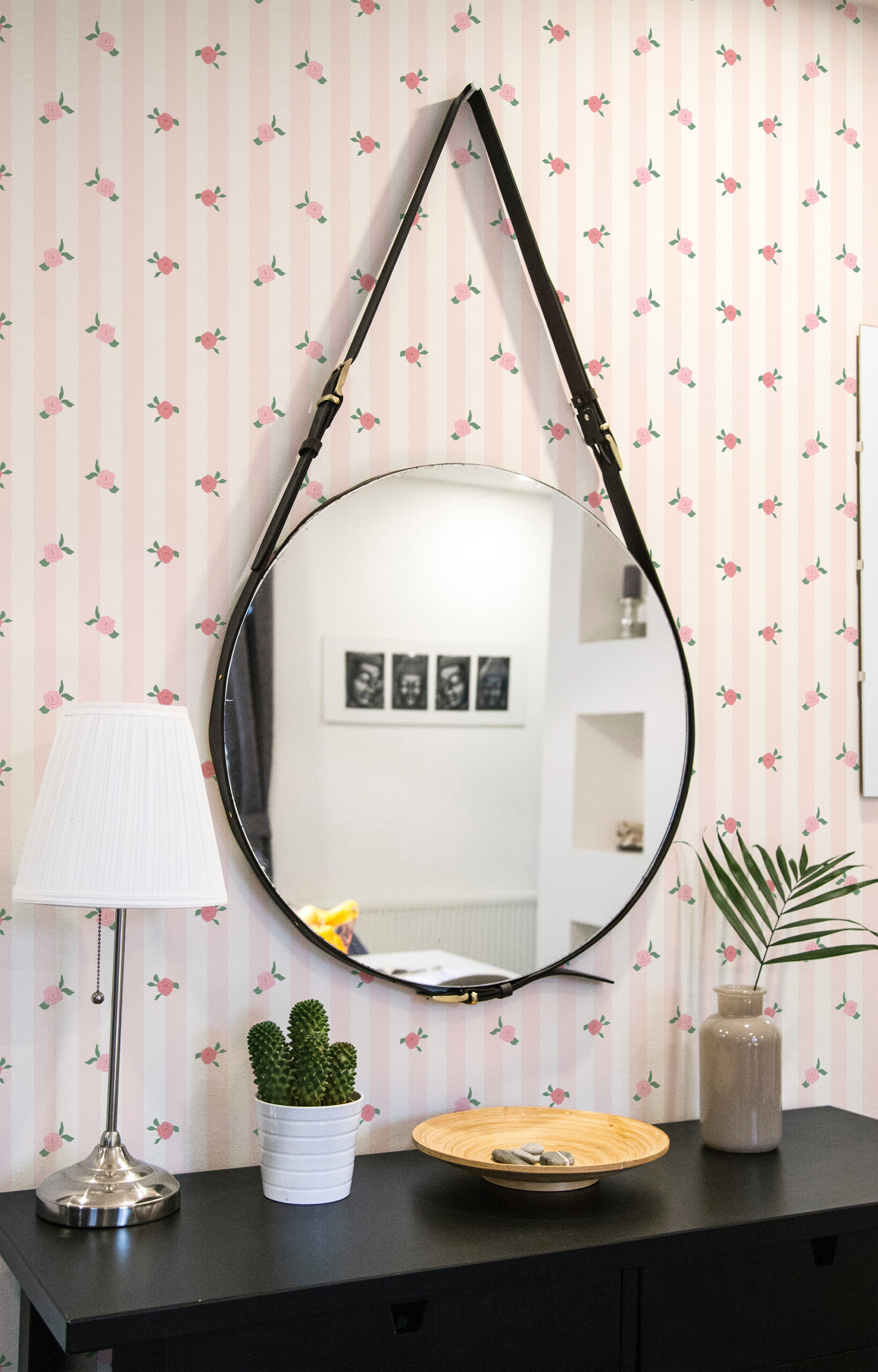 Vintage Pink Rose Stripe pre-pasted wallpaper with pale pink vertical stripes and scattered rosebuds behind a round mirror.