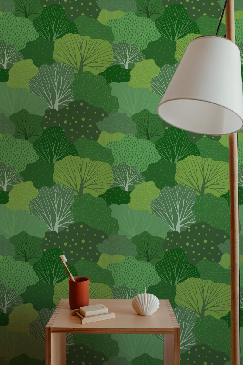 Whimsical Tree peel and stick wallpaper with layered leafy canopies in varied green tones behind a small vanity table.