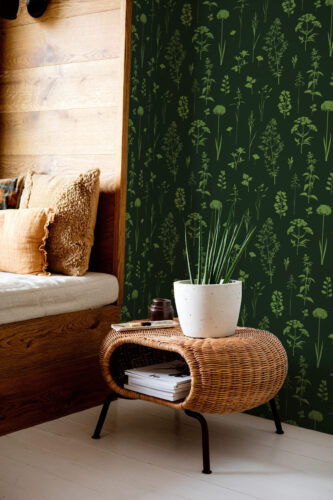 Green Botanical non-pasted wallpaper with scattered herb silhouettes on a deep green accent wall beside a bed.