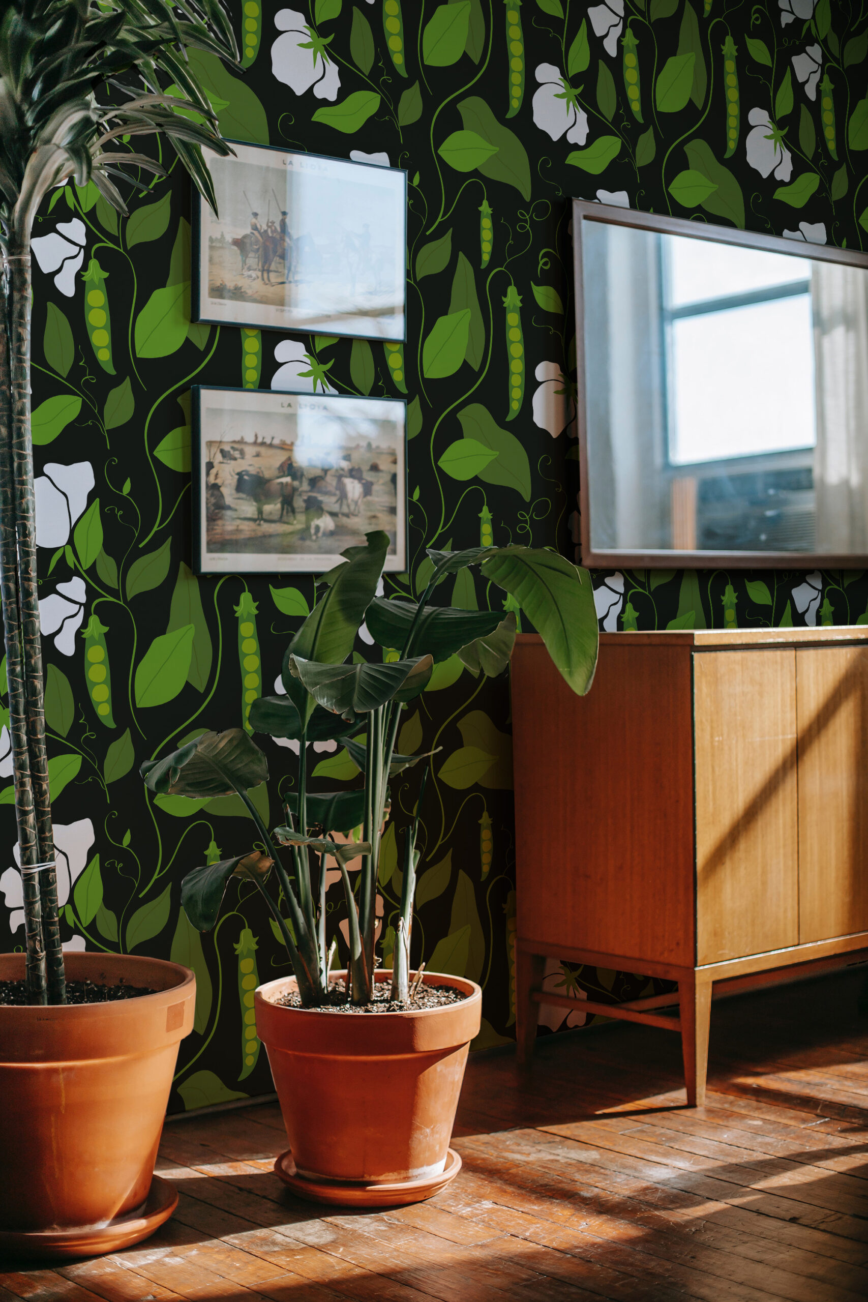 Bold Pea Pod pre-pasted wallpaper with green vines, leaves, and pea pods as an accent wall behind framed art and a mirror.