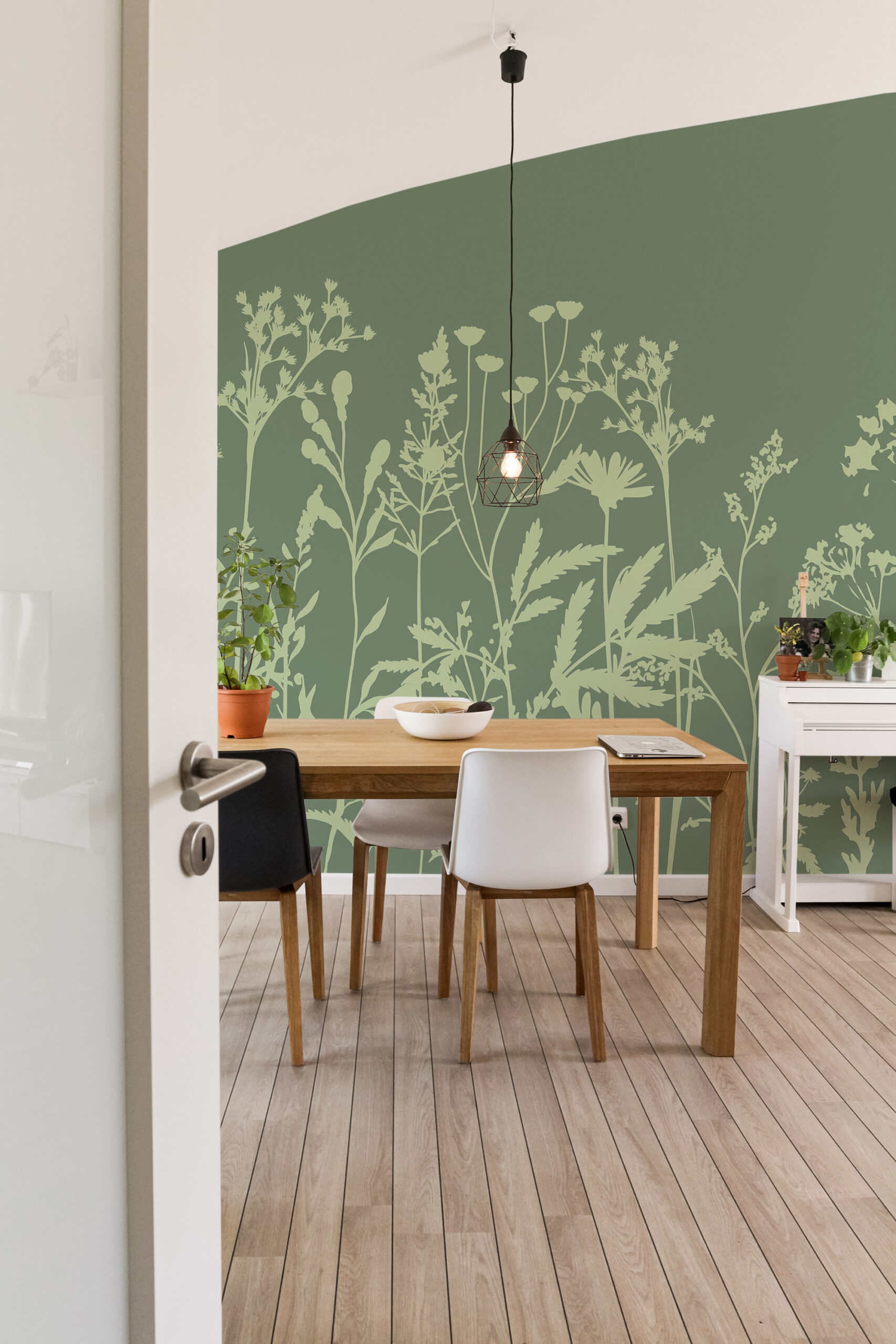 Green Meadow Wildflowers non-pasted wall mural covering a full dining room wall, with pale botanical silhouettes on deep green.
