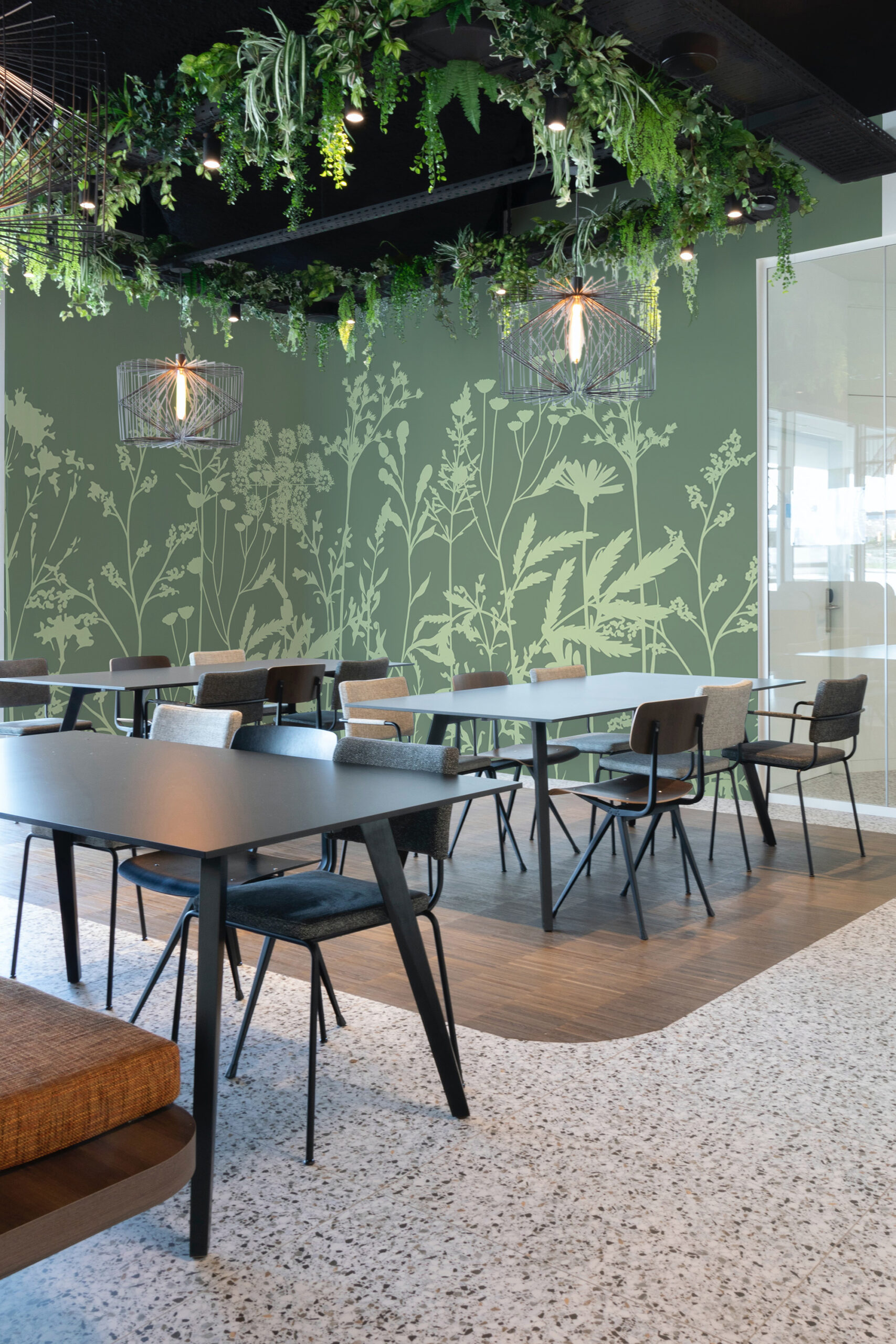 Green Meadow Wildflowers self-adhesive wall mural spanning the meeting room wall with pale botanical silhouettes on deep green.