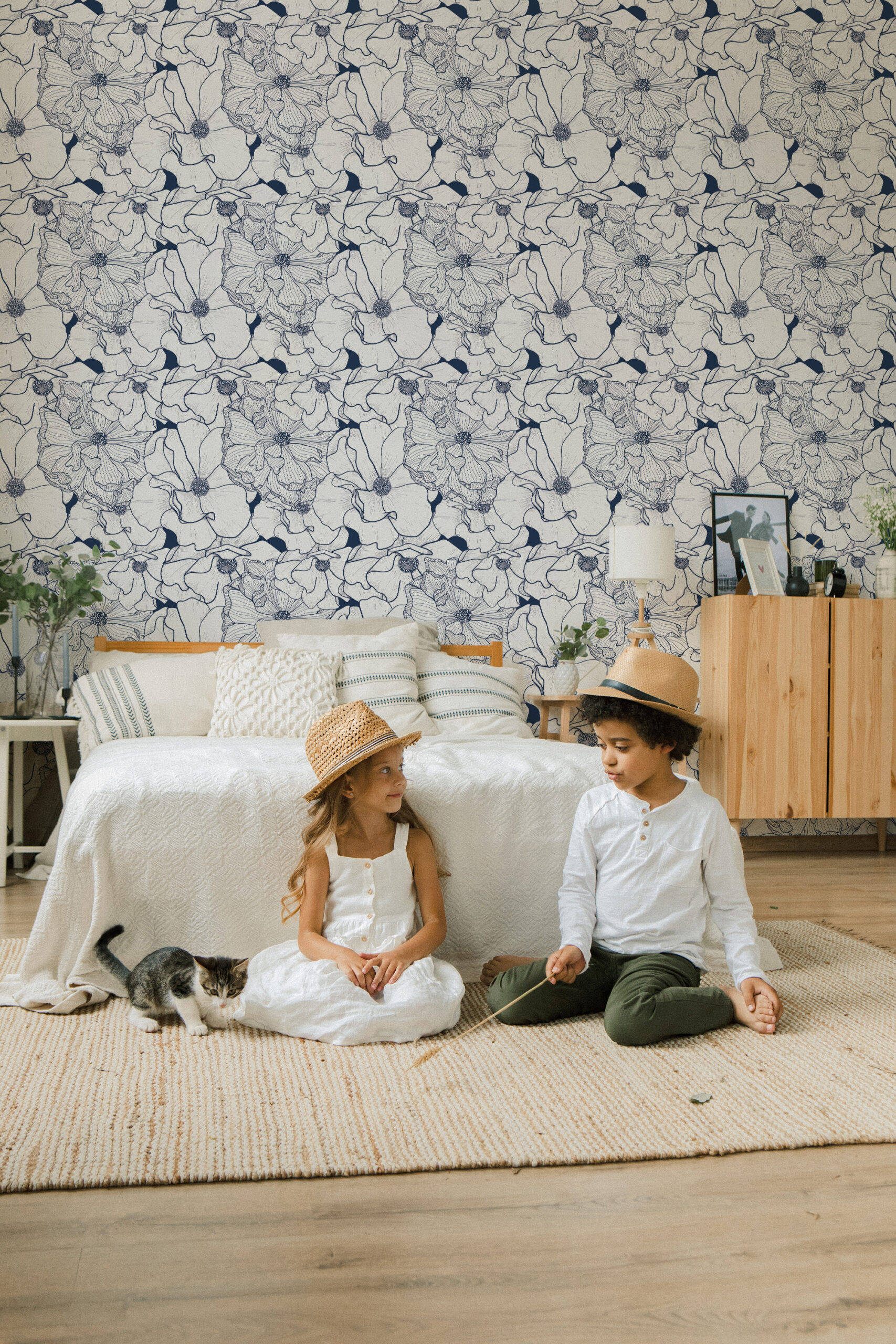 Bold Navy Flower pre-pasted wallpaper with large navy line-drawn blooms covering the bedroom wall behind the bed.