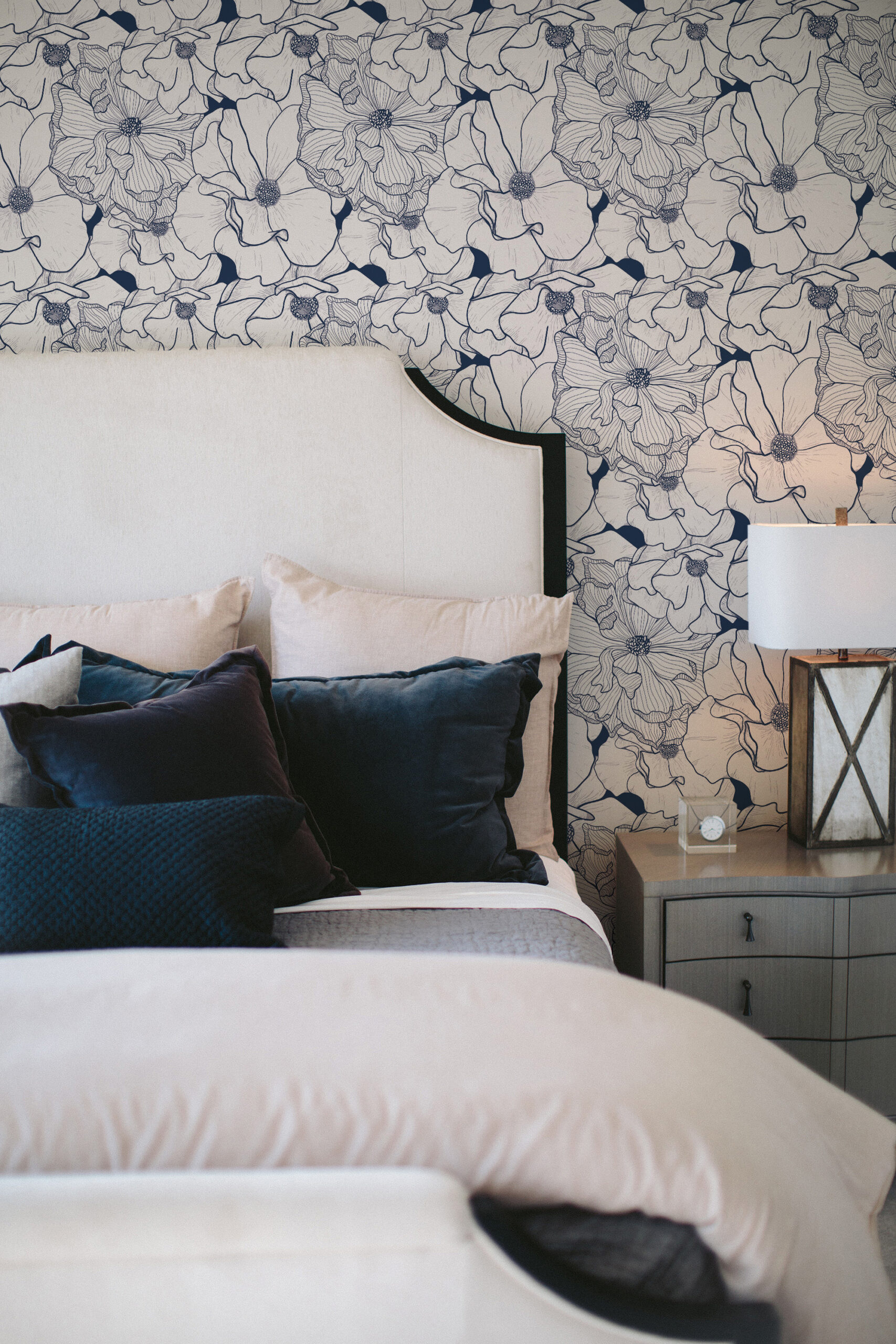 Bold Navy Flower non-pasted wallpaper in a bedroom, with large outlined blooms covering the wall behind the bed.
