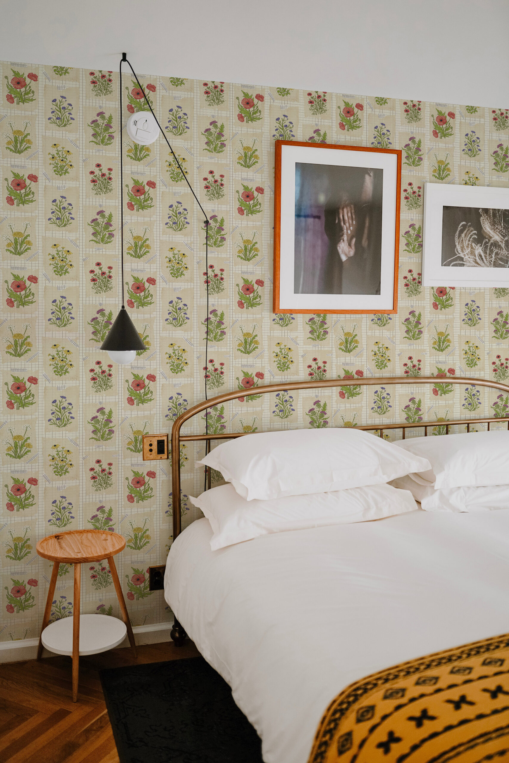 Vintage Cream Floral Collage pre-pasted wallpaper with small wildflower panels arranged in a grid behind a bed.