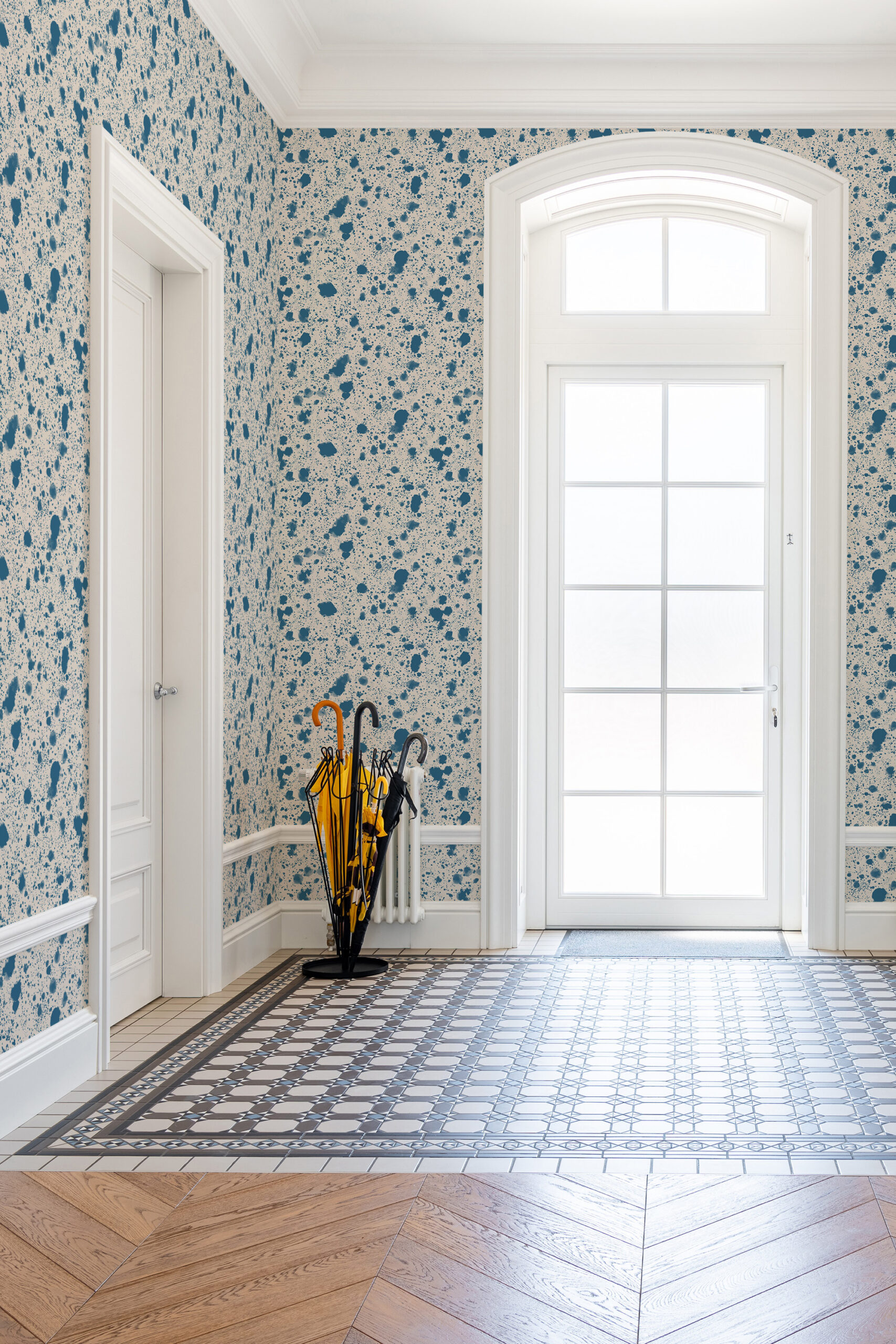 Fine Blue Splatter pre-pasted wallpaper covers an entryway wall with scattered blue paint splashes around a tall glass door.
