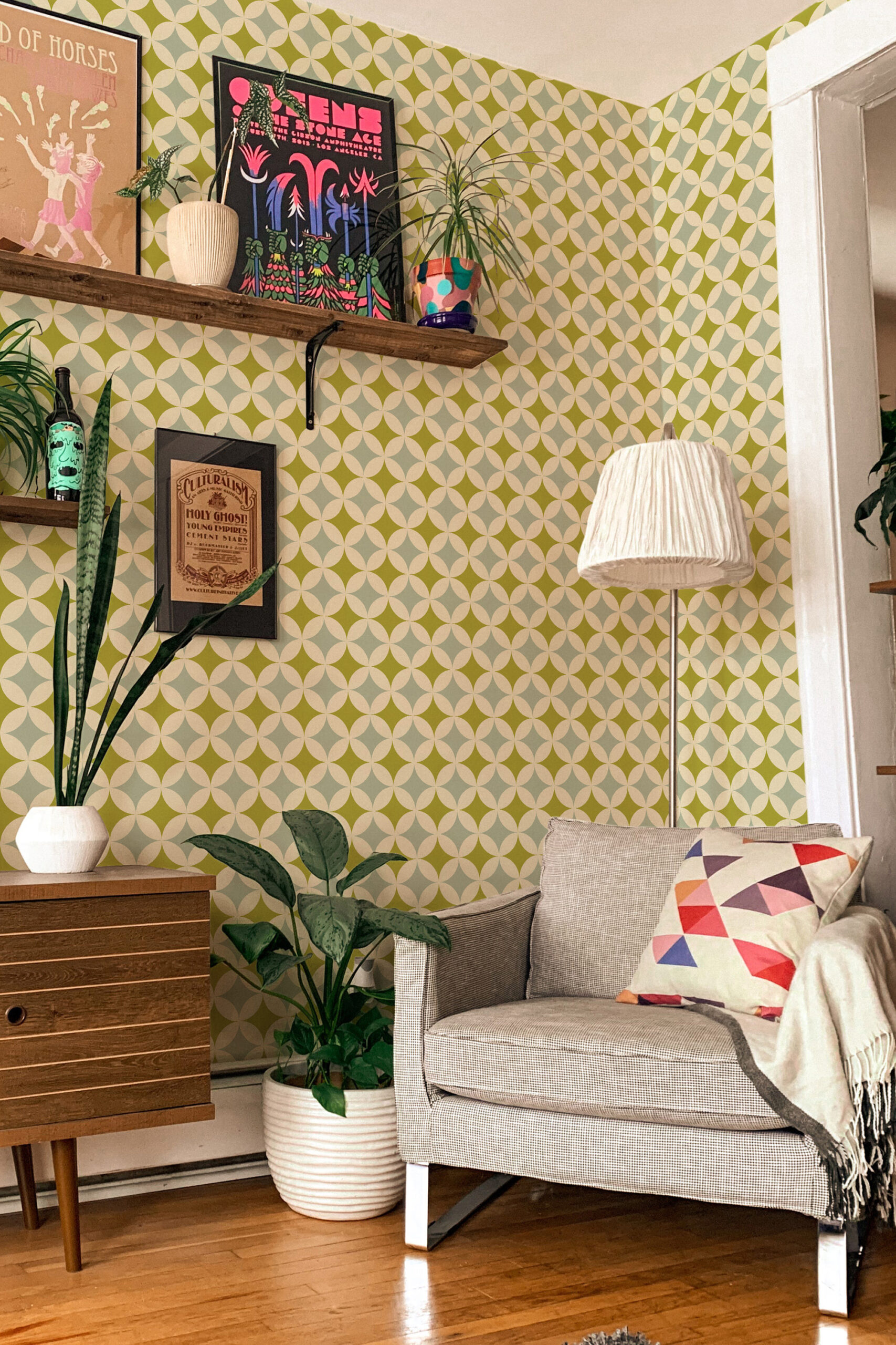 Green Retro Geometric pre-pasted wallpaper with an olive and cream curved diamond pattern on a living room wall.