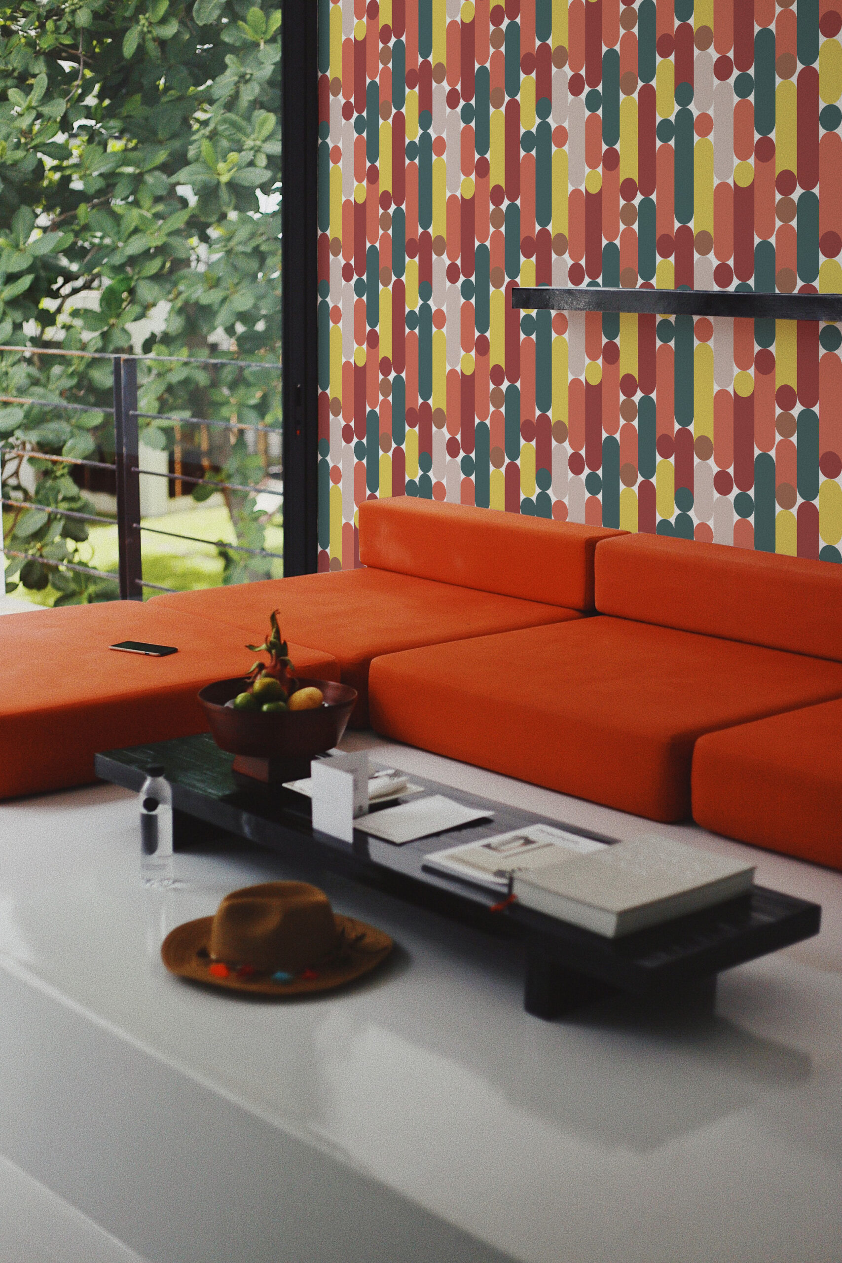 Retro White Capsule Geometric peel and stick wallpaper covering an accent wall of colorful capsule stripes behind an orange sofa.