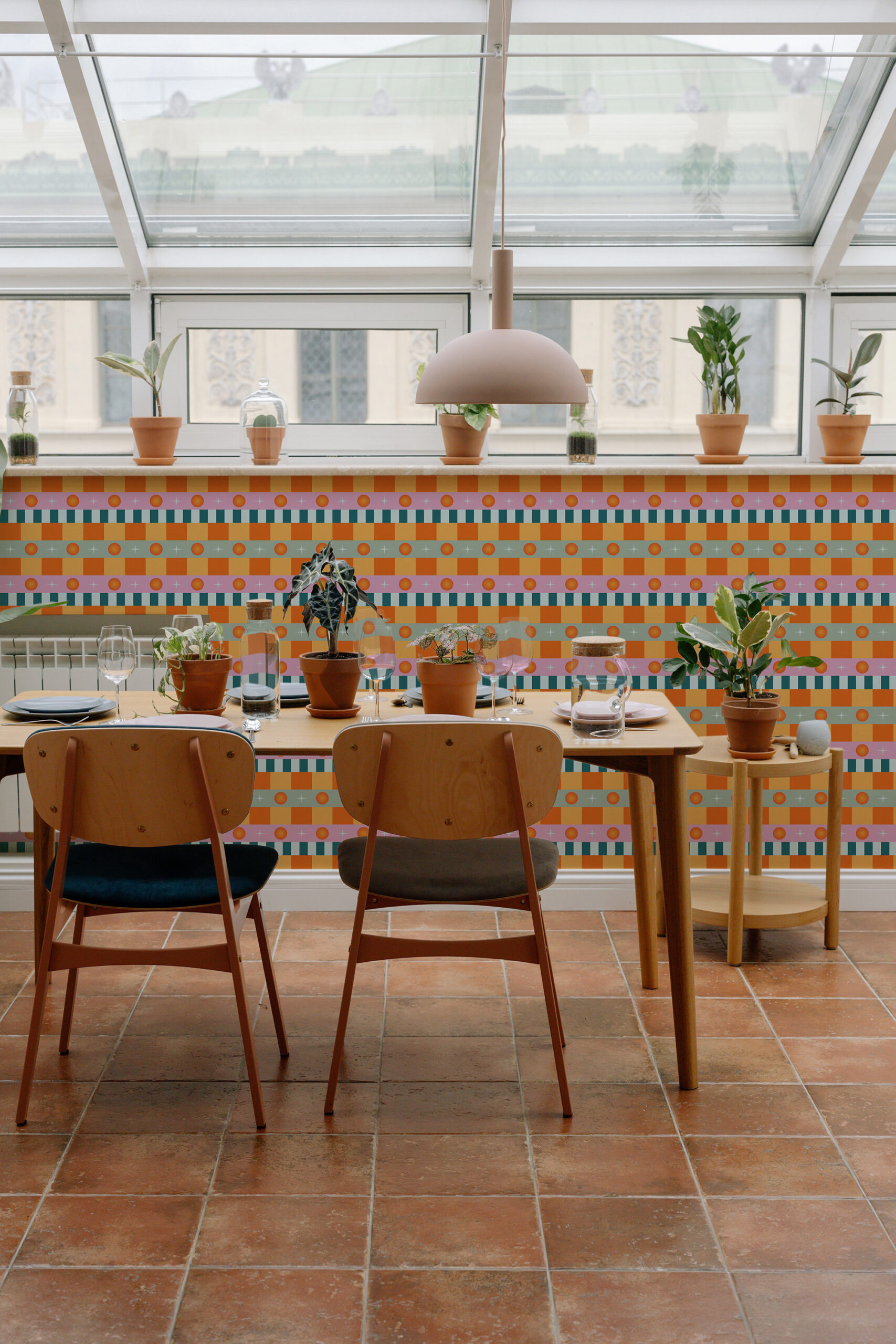 Retro Orange Stripe pnon-pasted wallpaper with horizontal stripes and dot bands, used as a bright accent wall behind a dining table.