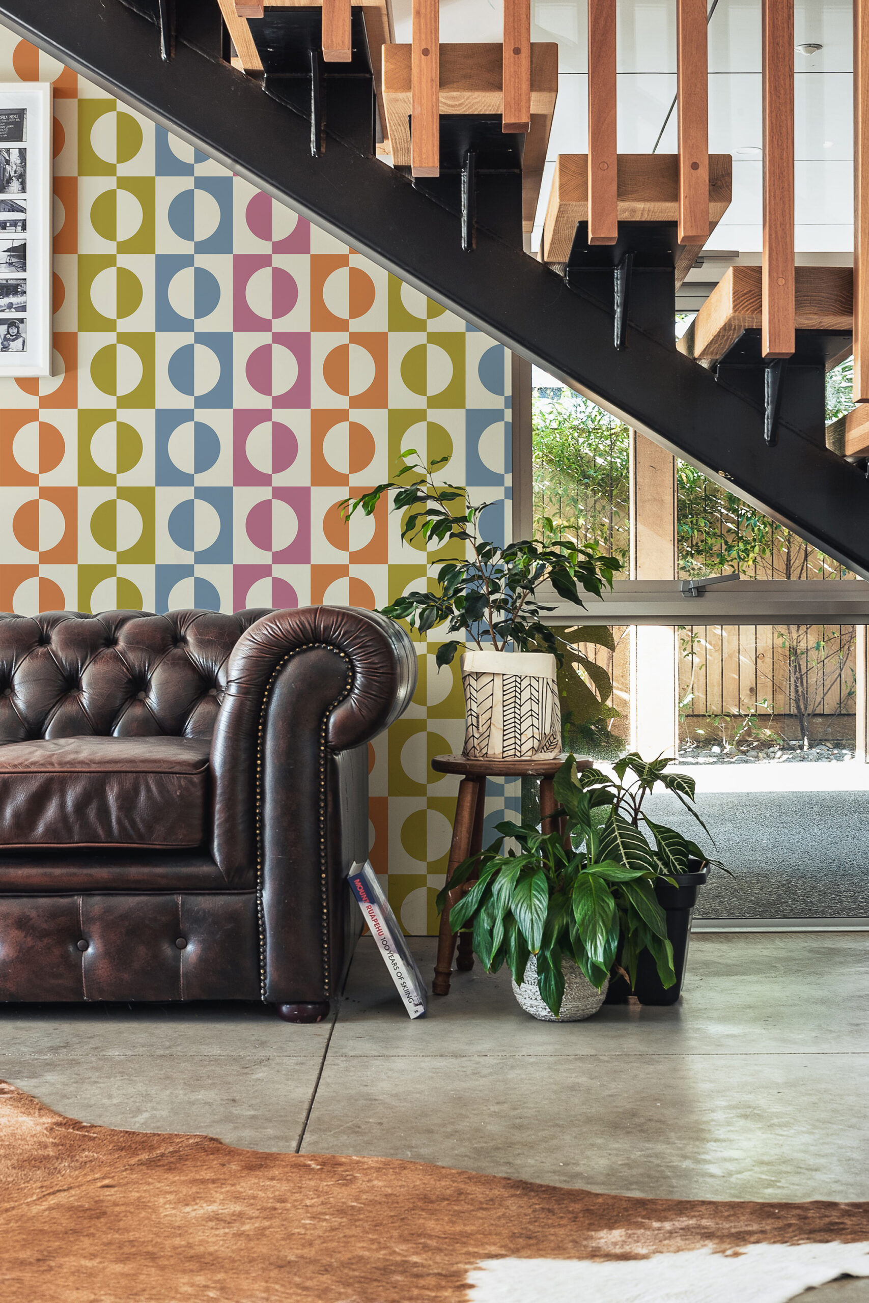 Retro Multicolored Split Circle self-adhesive wallpaper with colorful half-circle blocks on an accent wall beneath a modern staircase.