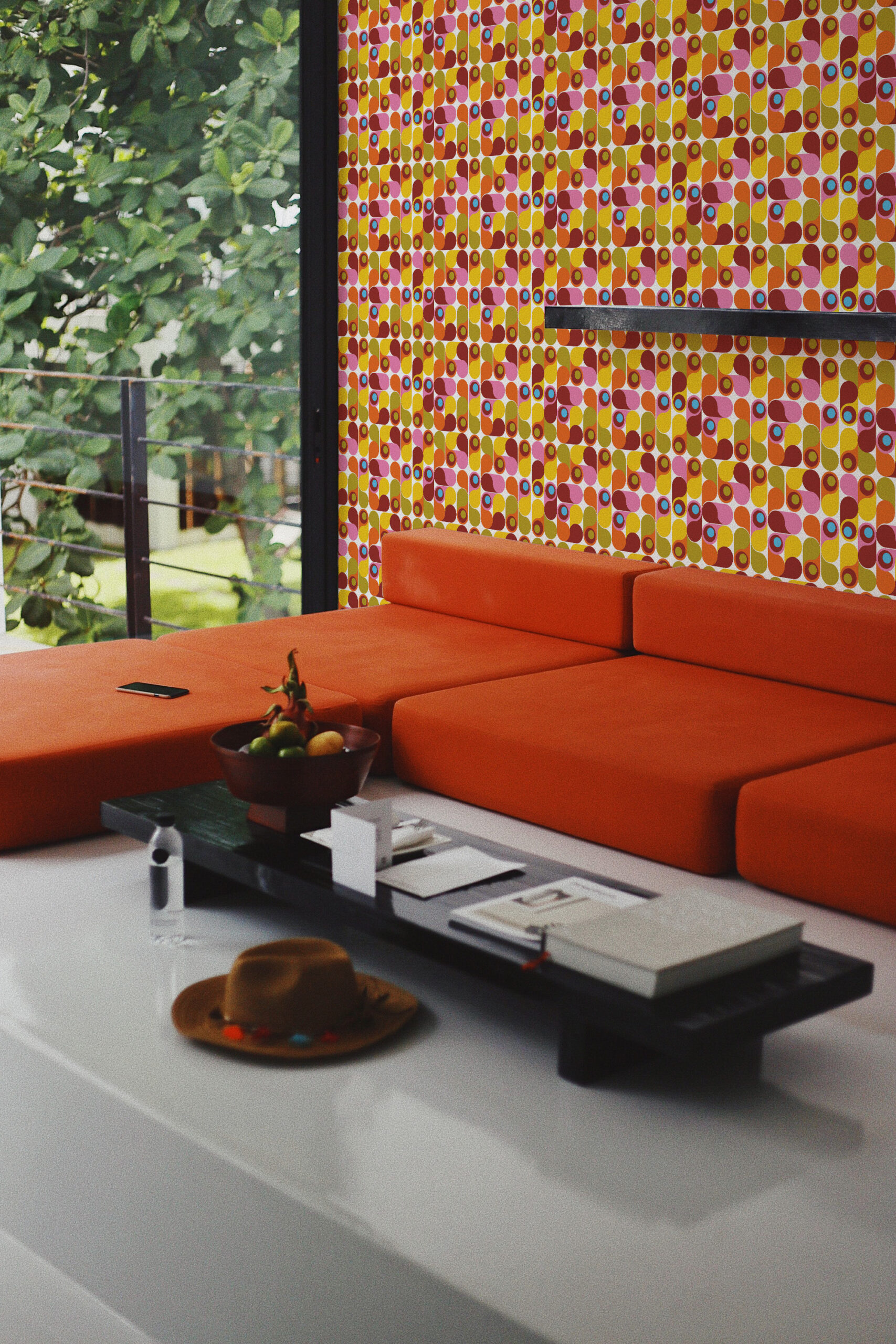 Colorful Retro Teardrop Shapes self-adhesive wallpaper with a geometric tile pattern behind an orange sectional sofa.