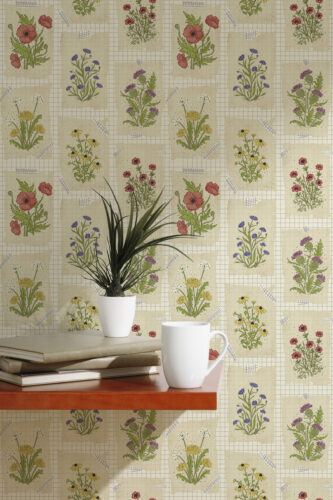Vintage Cream Floral Collage peel and stick wallpaper with taped botanical sketches over a cream grid, shown behind a table.