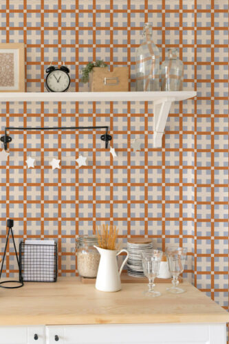 Orange Retro Cross Grid peel and stick wallpaper in a kitchen setting, with orange lines and gray cross tiles behind shelves.