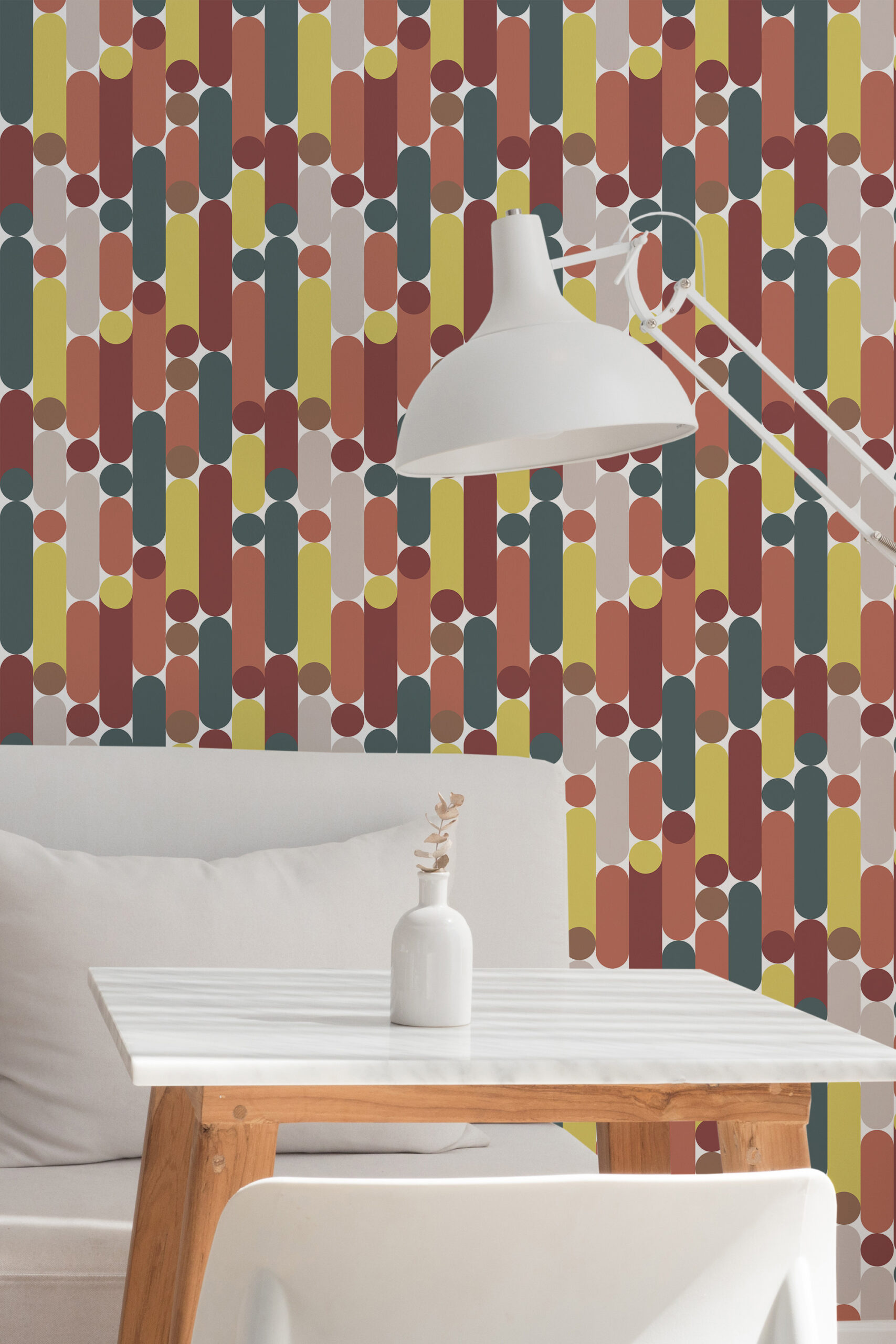 Retro White Capsule Geometric peel and stick wallpaper with colorful capsule shapes and dots behind a white table and lamp.