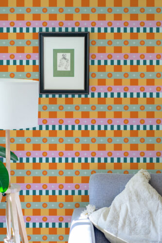 Retro Orange Stripe pre-pasted wallpaper with layered horizontal bands of orange checks, teal stripes, and dot rows behind a framed print.