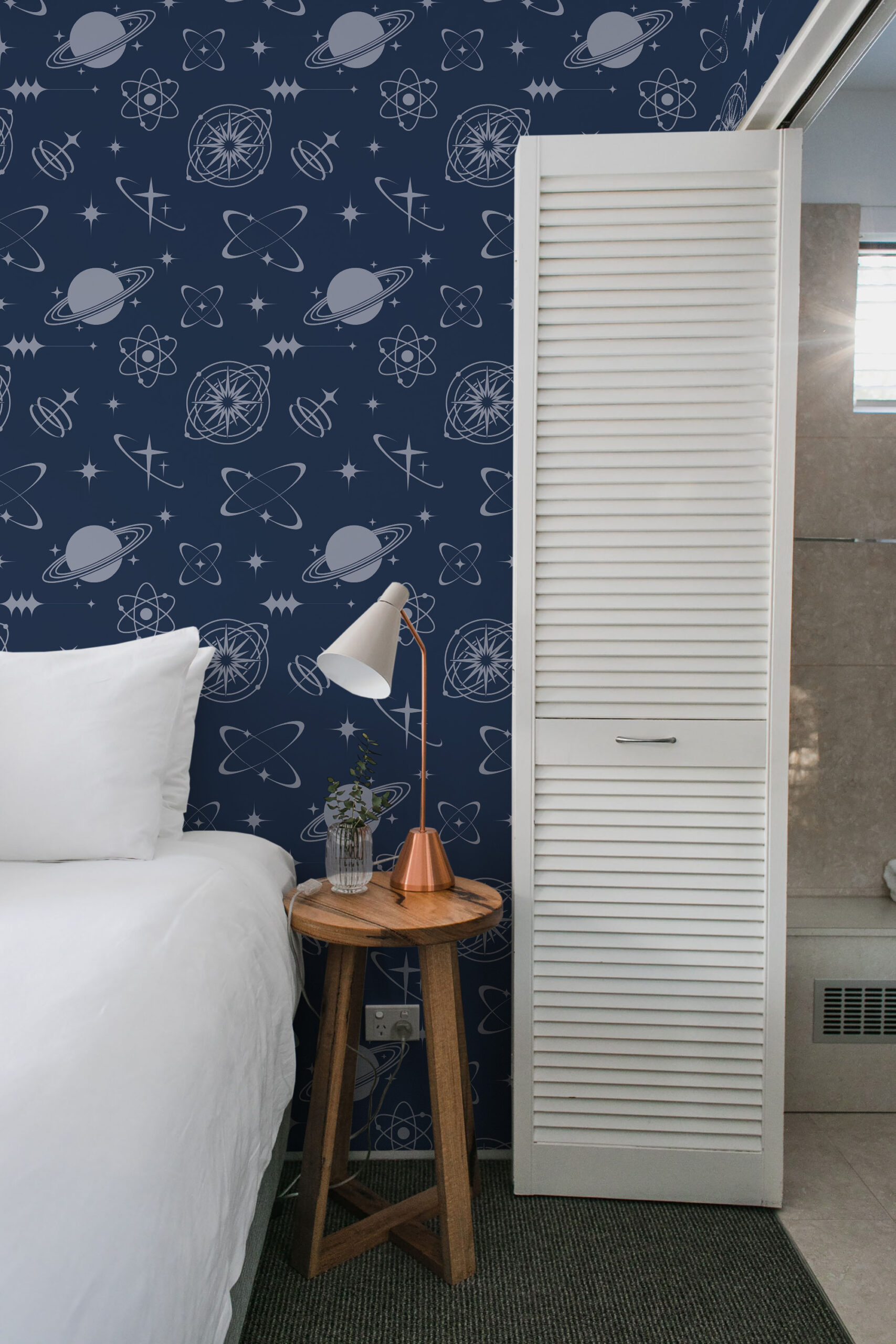 Retro Navy Blue Celestial pre-pasted wallpaper with planets, stars, and atomic symbols on a dark blue bedroom wall.