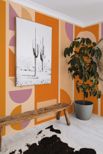Burnt Orange Geometric Columns features a wall mural of bold orange blocks with peach and mauve arches across a corner wall.