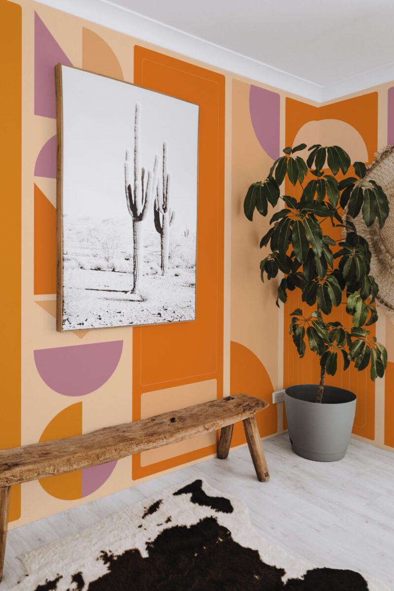 Burnt Orange Geometric Columns features a wall mural of bold orange blocks with peach and mauve arches across a corner wall.