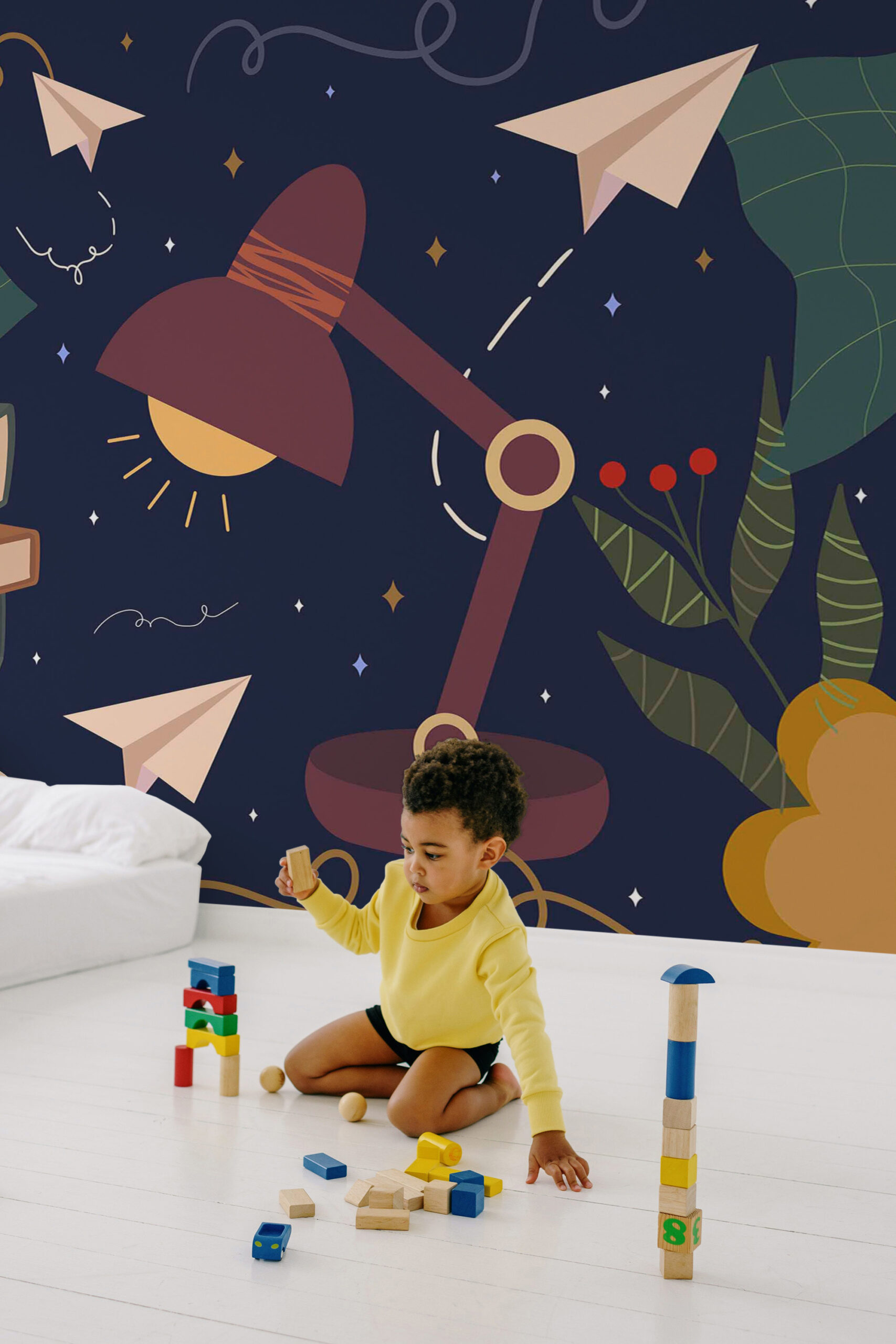 Whimsical Study Desk peel and stick wall mural with desk lamp, paper airplanes, stars, and leafy shapes across a dark navy background.