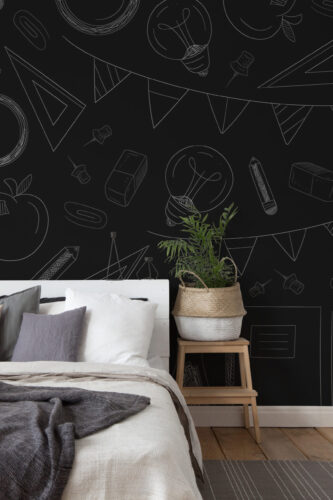 Chalkboard School Doodles pre-pasted wall mural with white chalk-style school icons and geometric shapes across the wall behind a bed.
