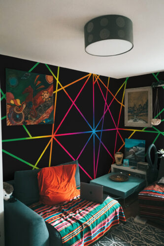 Neon Geometric Mesh wall mural with bright intersecting lines on a black accent wall behind the bed.