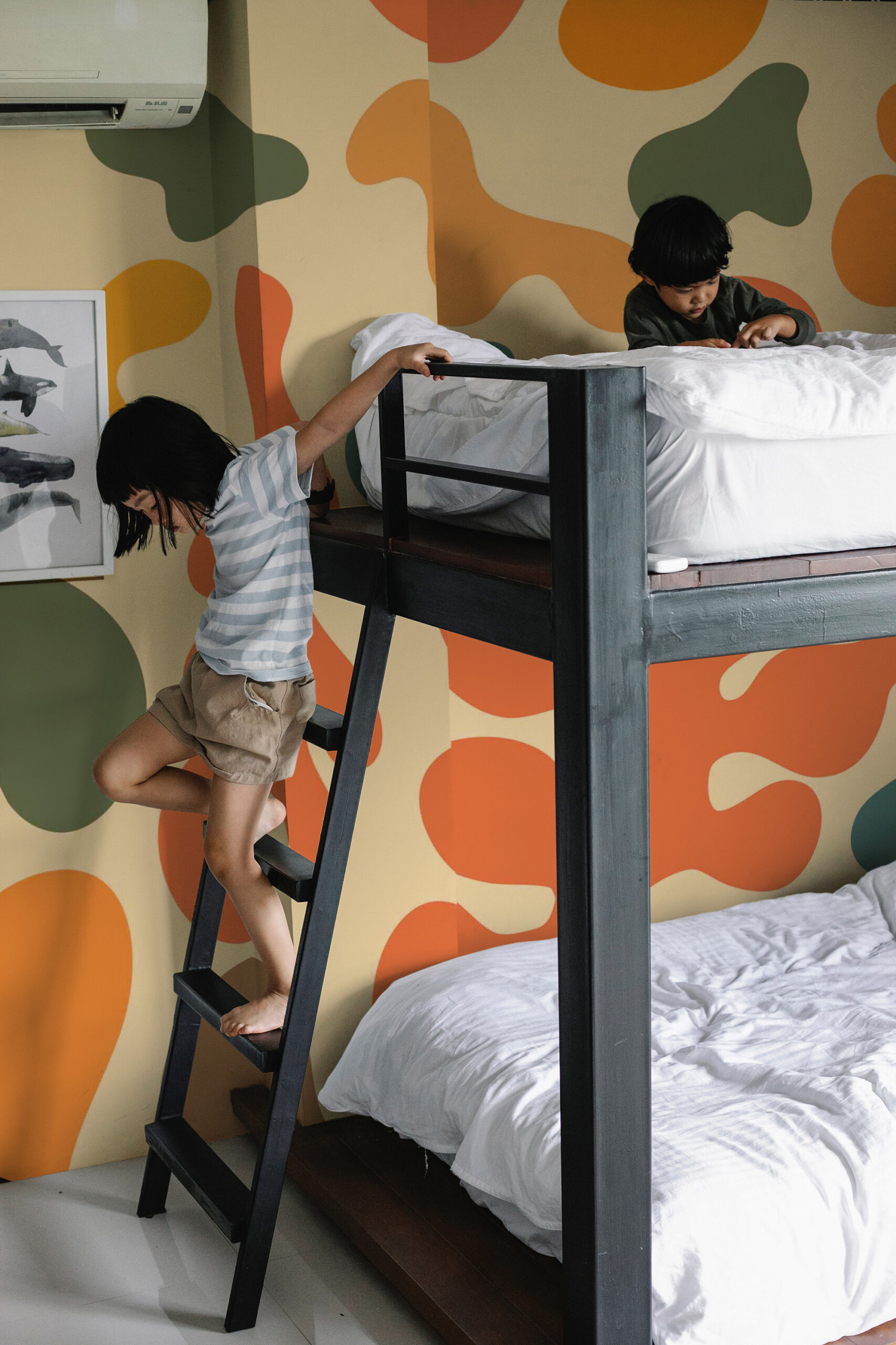 Retro Abstract Color Splash pre-pasted wall mural wraps a kids bedroom behind a dark wood bunk bed with bold organic shapes.