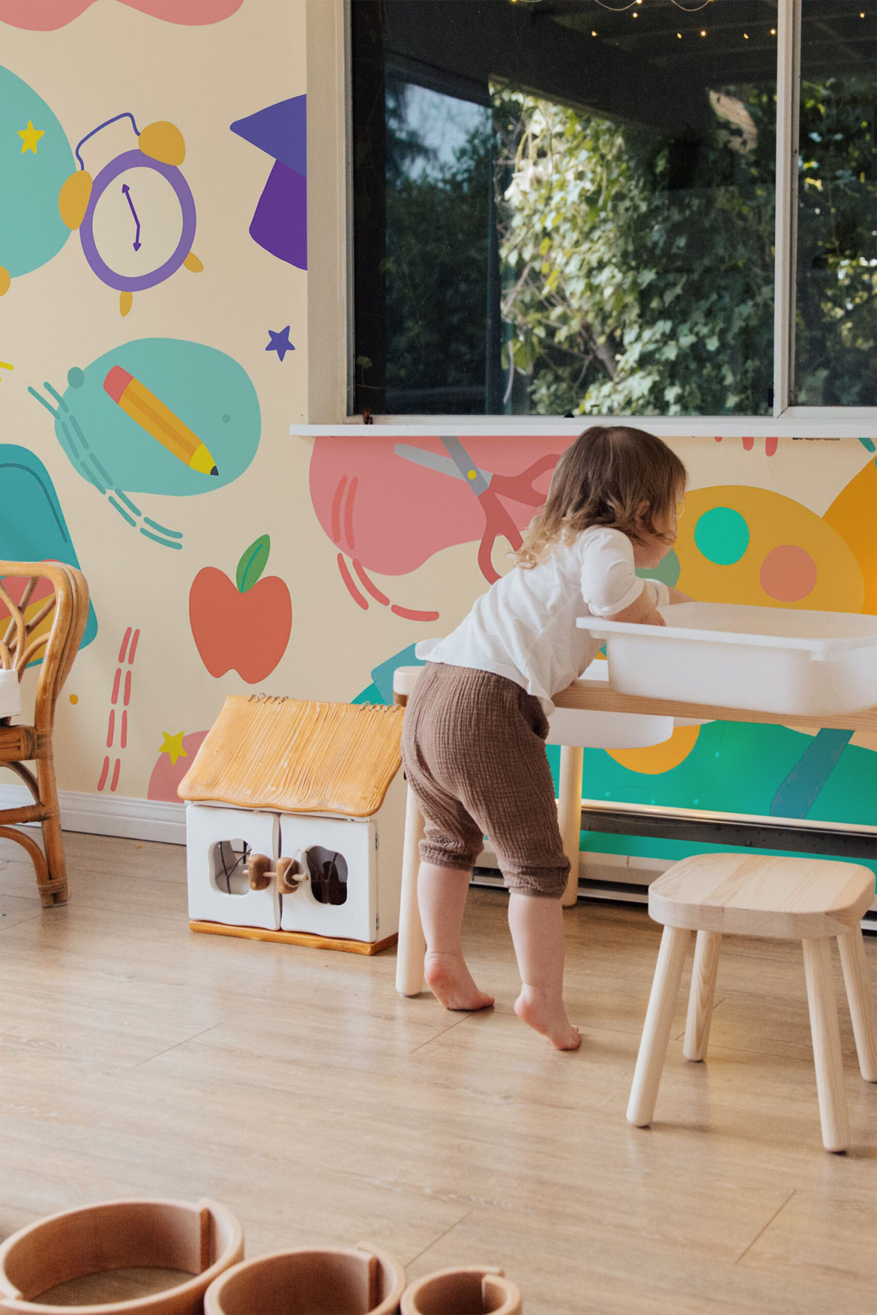 Playful School Supplies non-pasted wall mural wraps an accent wall in bold illustrations of pencils, apples, scissors, and an alarm clock.