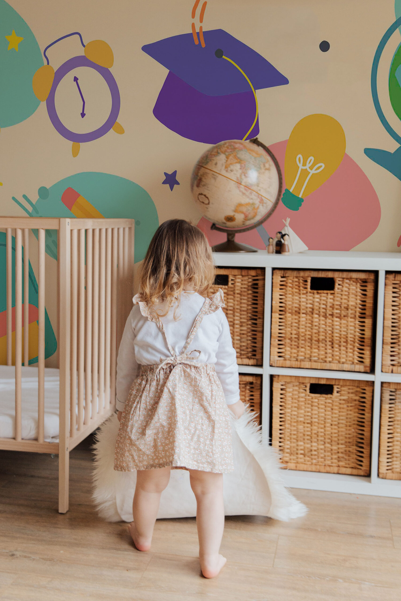 Playful School Supplies wall mural with colorful graduation cap, clock, pencil, and lightbulb shapes across a full wall.
